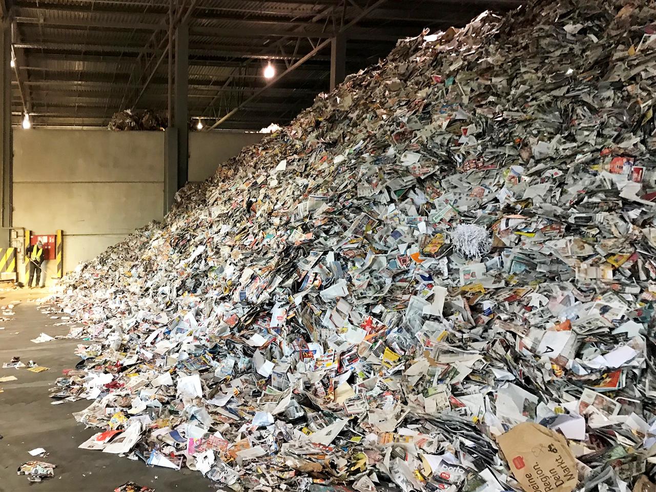 Blick in eine Halle mit einem riesengroßen Berg aus Altpapier. Blick in eine Halle mit einem riesengroßen Berg aus Altpapier.