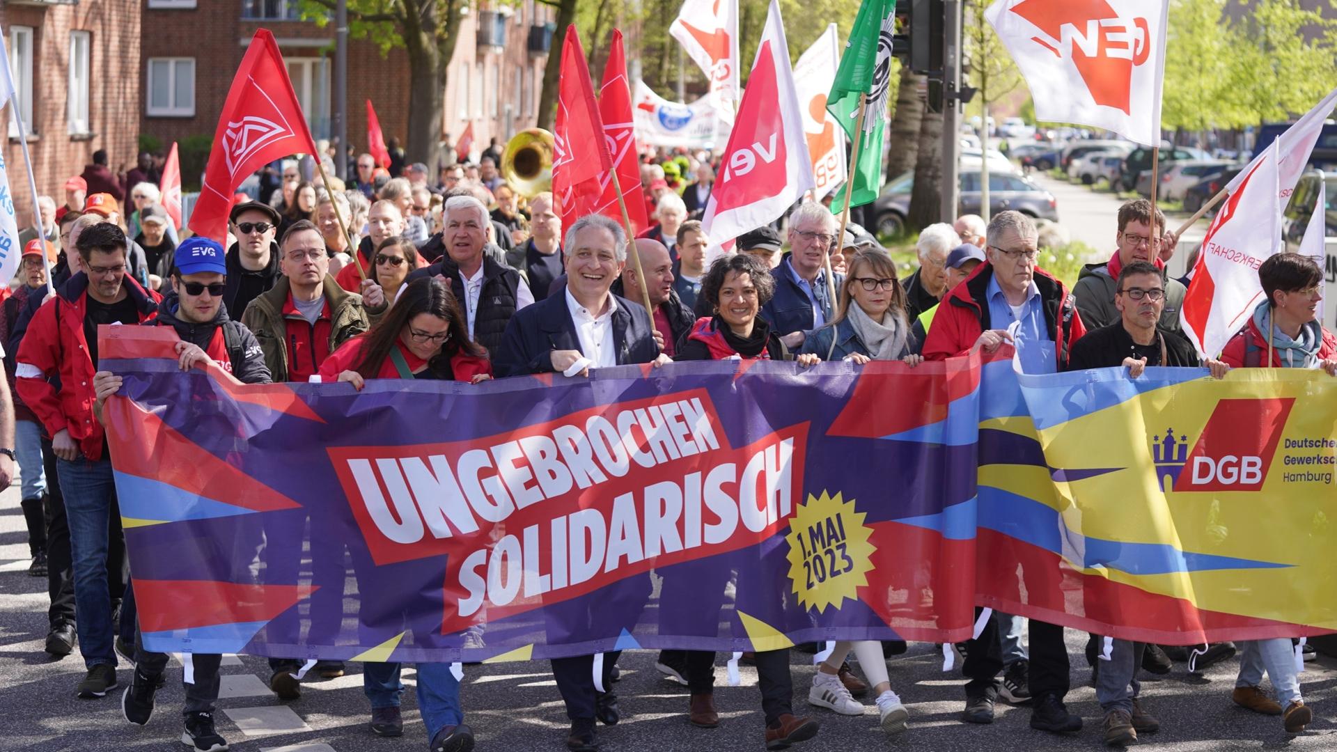 Kundgebung zum Tag der Arbeit am 1. Mai 2023 in Hamburg, Demonstrierende und Vertreterinnen von DGB und IG Metall tragen ein Banner mit dem diesjährigen Motto "Ungebrochen solidarisch". Kundgebung zum Tag der Arbeit am 1. Mai 2023 in Hamburg, Demonstrierende und Vertreterinnen von DGB und IG Metall tragen ein Banner mit dem diesjährigen Motto "Ungebrochen solidarisch".