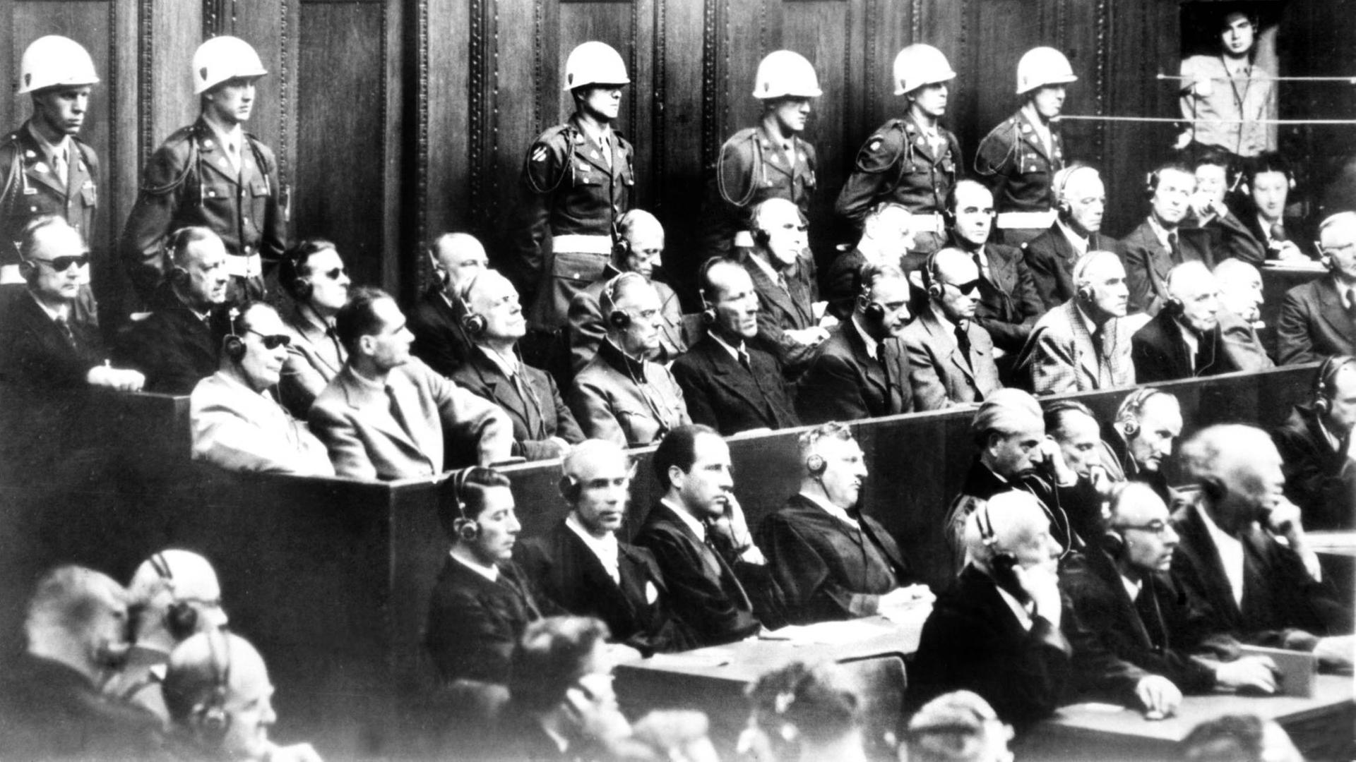 Bei den Nürnberger 1945 Prozessen sitzen die Angeklagten auf der Anklagebank. Bei den Nürnberger 1945 Prozessen sitzen die Angeklagten auf der Anklagebank.