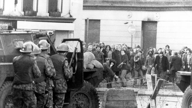 In Londonderry in Nordirland stehen sich am 30. Januar 1972, dem Blutigen Sonntag, Demonstrantinnen und Demonstranten und  britische Truppen gegenüber. 