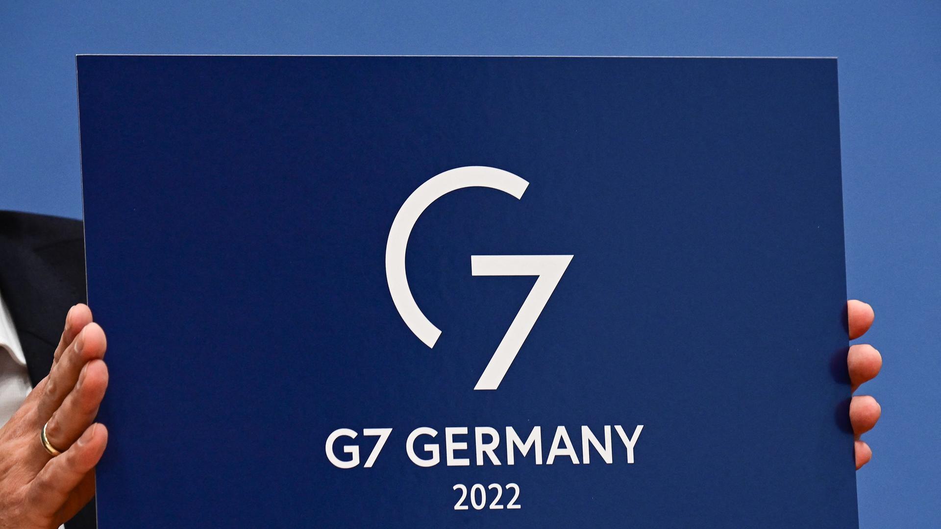 Regierungssprecher Steffen Hebestreit präsentiert das Logo des deutschen G7-Vorsitzes.
