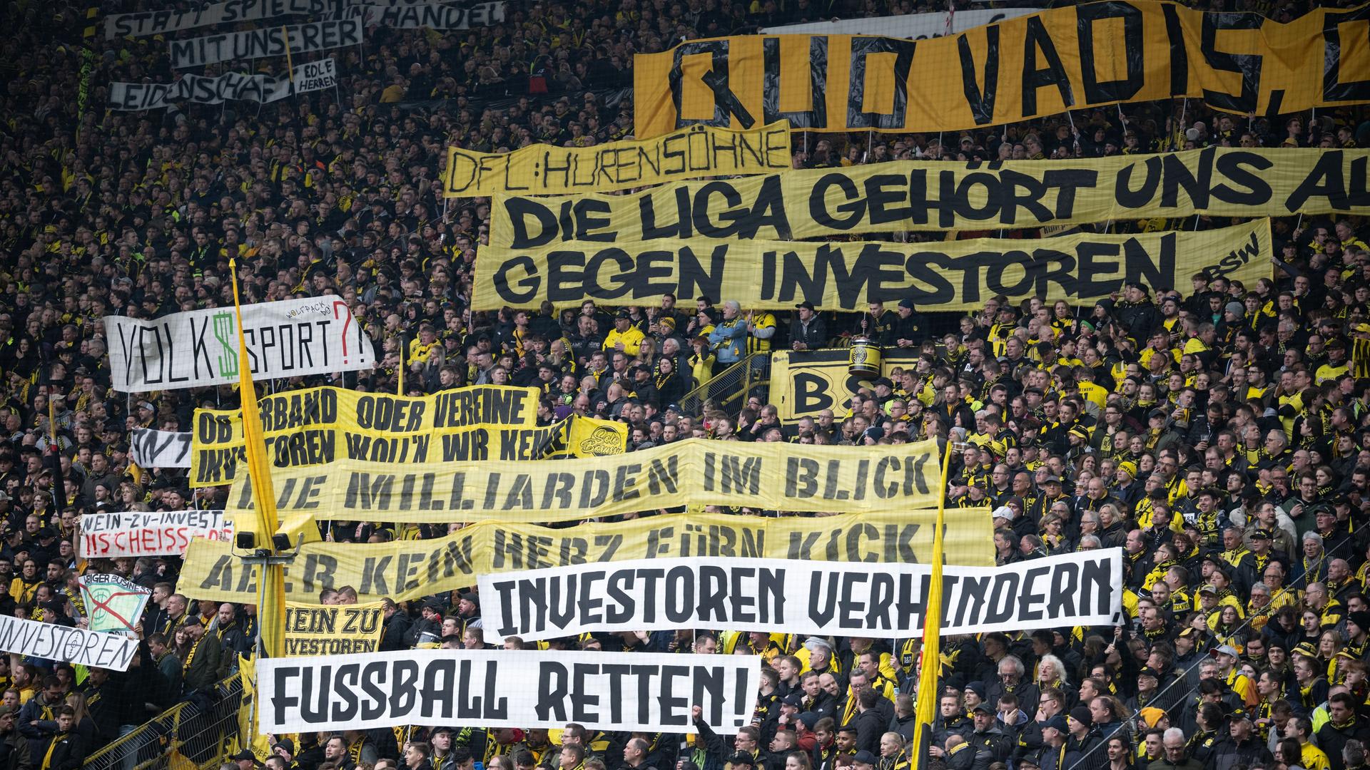 Transparente mit den Aufschriften: "DFL Hurensöhne", "Die Liga gehört uns ...", "Gegen Investoren", "Die Milliarden im Blick", "Kein Herz fürn Kick", "Investoren verhindern" sowie "Fußball retten".