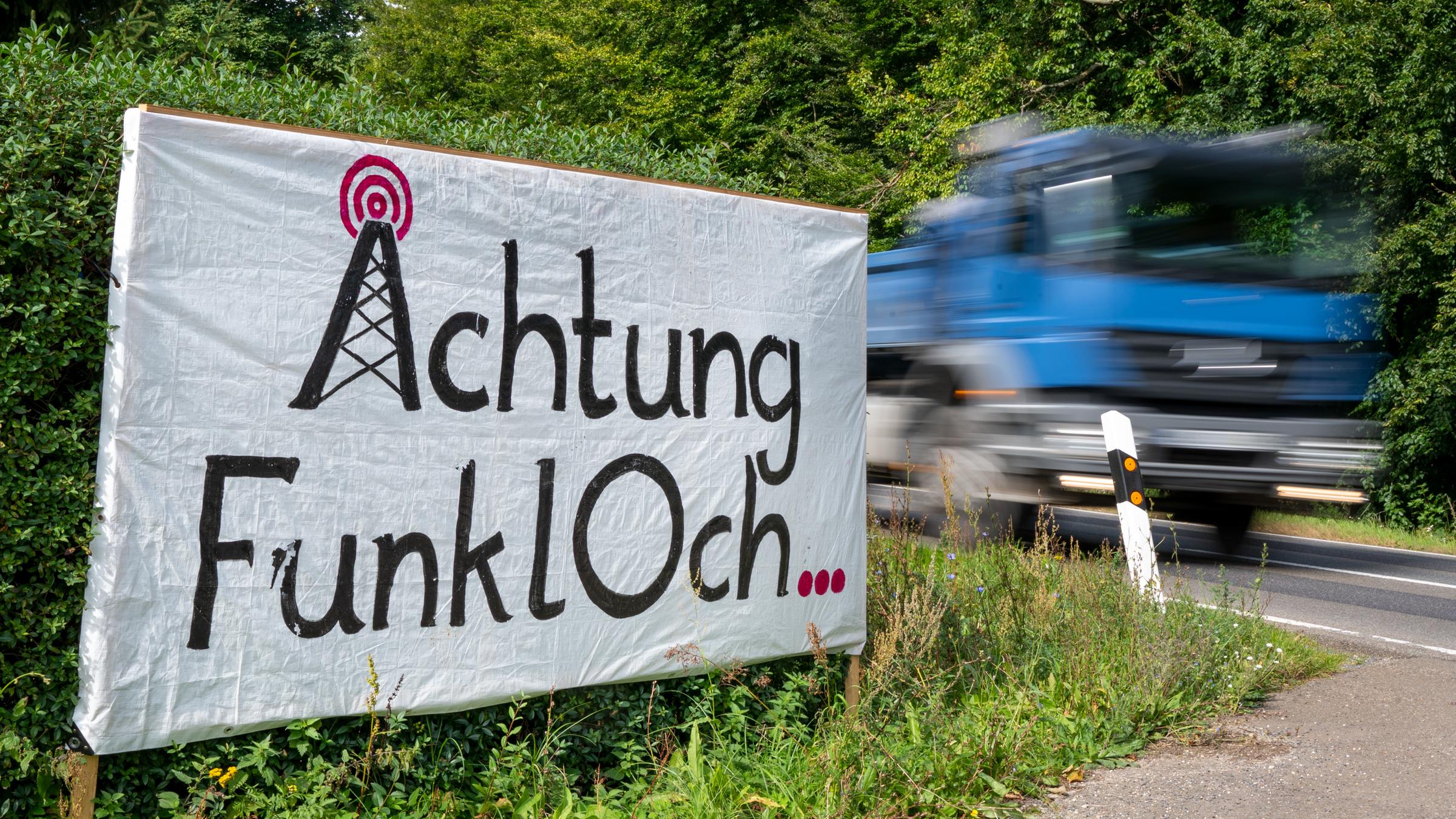Ein Schild mit der Aufschrift "Achtung Funkloch" steht an einer Straße bei Prötzel in Brandenburg.