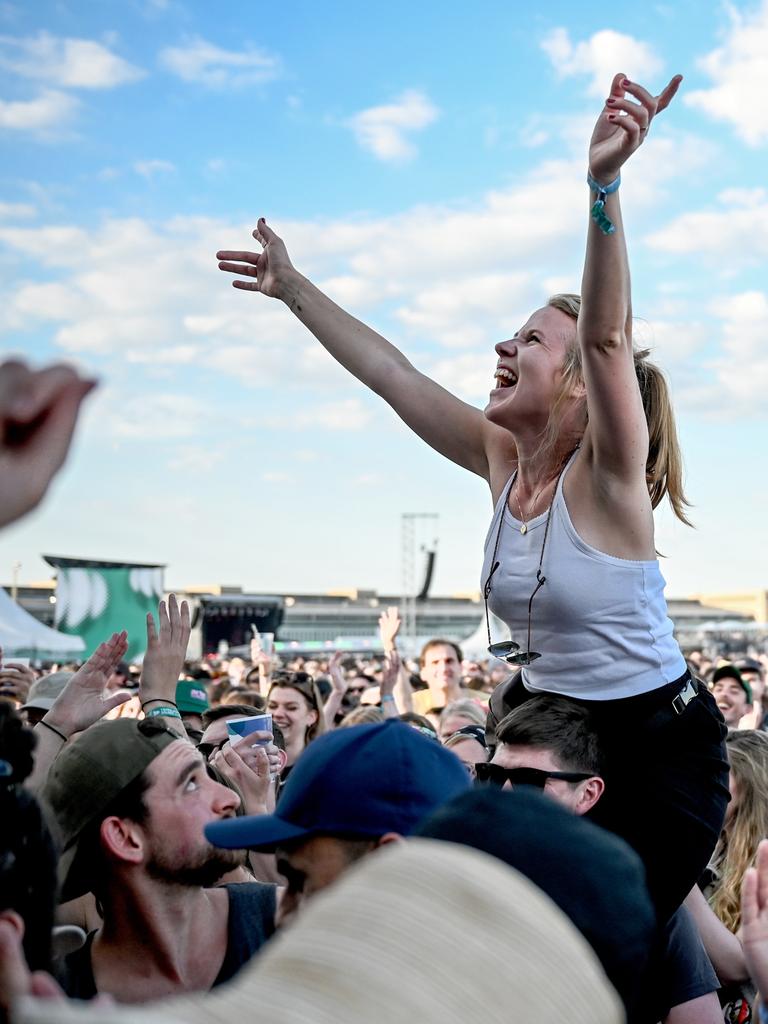 Das Publikum feiert beim Tempelhof-Sounds Festival auf dem Gelände des ehemaligen Flughafen Berlin Tempelhof. Eine junge Frau ist auf den Schultern eines anderen Besuchers und freut sich.