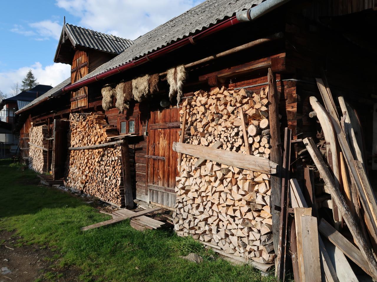 Ein altes Holzhaus mit Stapeln von Holzscheiten davor