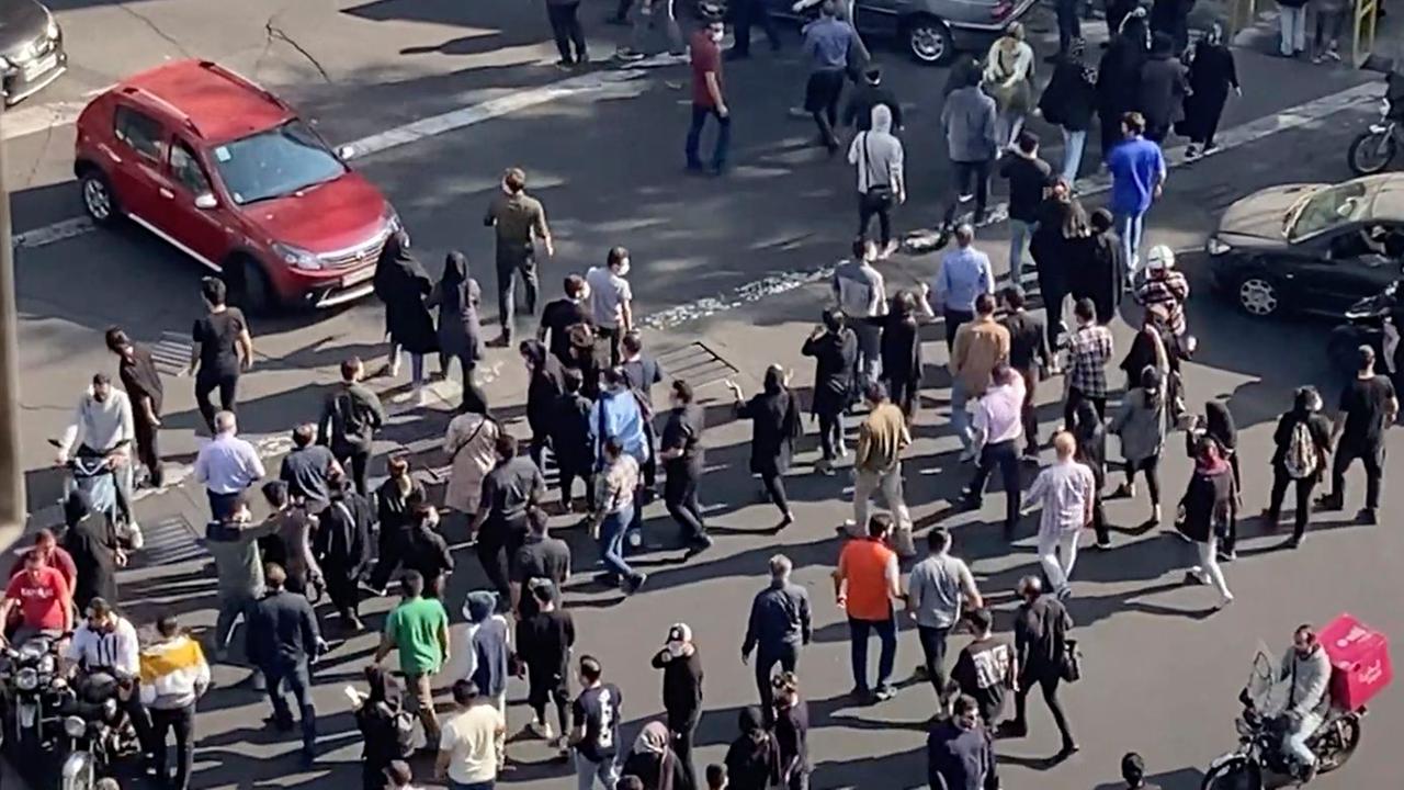 Im Iran blockieren Menschen während einer Demonstration eine Kreuzung. 