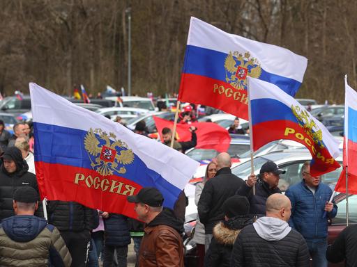Demonstranten stehen mit russischen Fahnen auf dem Tänzelfestplatz in Kaufbeuren