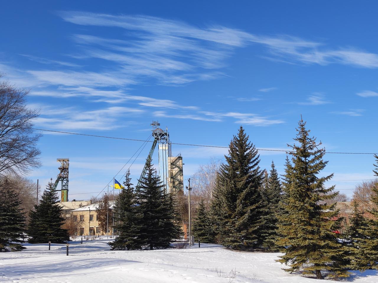 Minengebäude und ein Förderturm zwischen Tannen im Schnee. Minengebäude und ein Förderturm zwischen Tannen im Schnee.