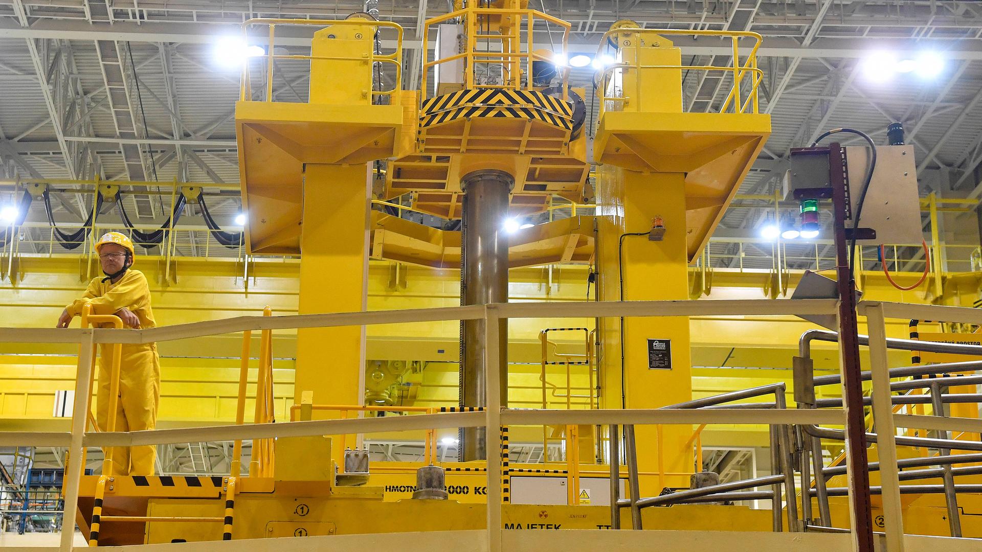 Das tschechische Atomkraftwerk von innen mit einem Arbeiter, der Schutzkleidung trägt. Das tschechische Atomkraftwerk von innen mit einem Arbeiter, der Schutzkleidung trägt.