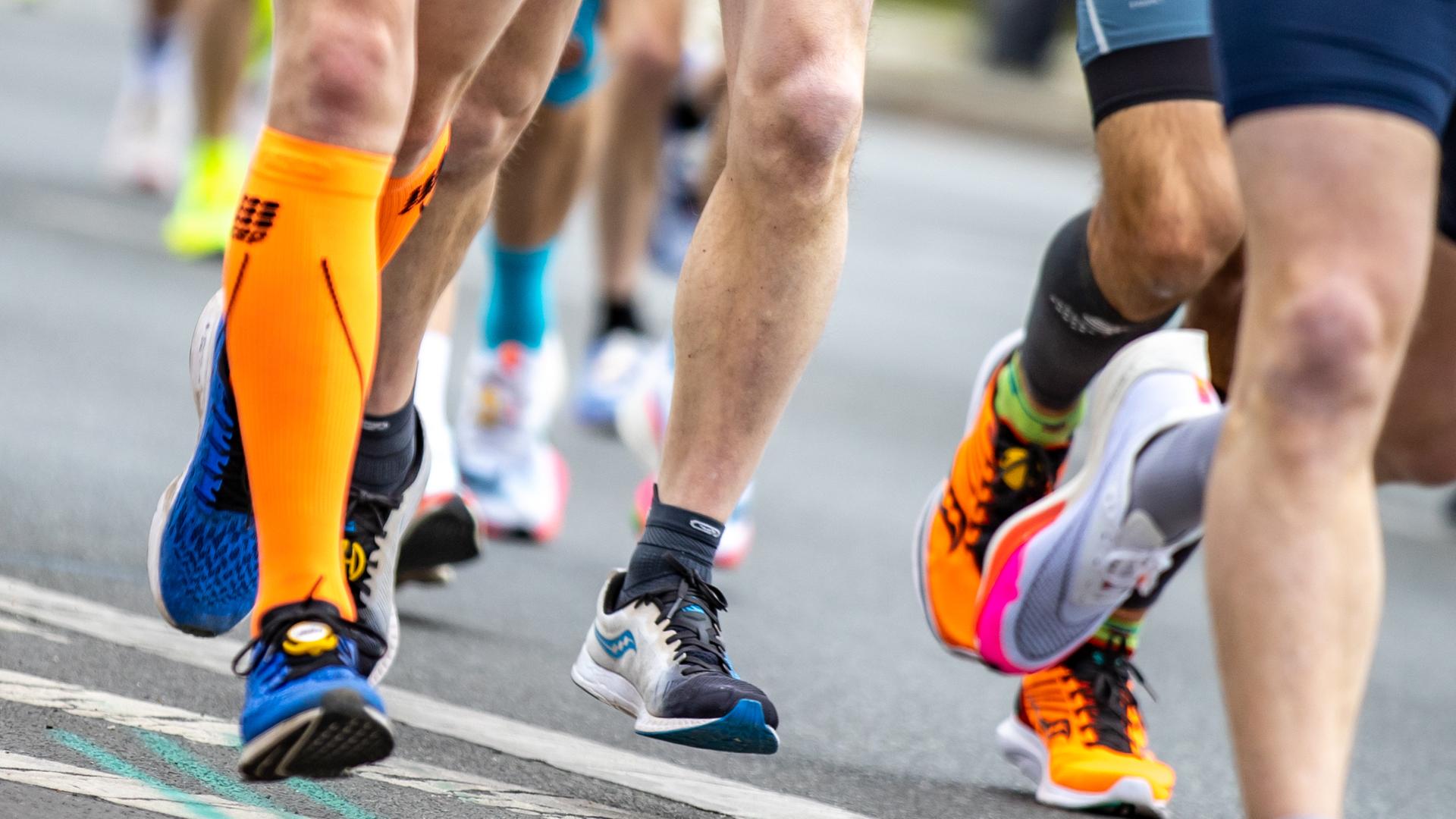 Nahaufnahme von Laufschuhen, Waden und Beinen der Läufer auf einer Strasse. Nahaufnahme von Laufschuhen, Waden und Beinen der Läufer auf einer Strasse.
