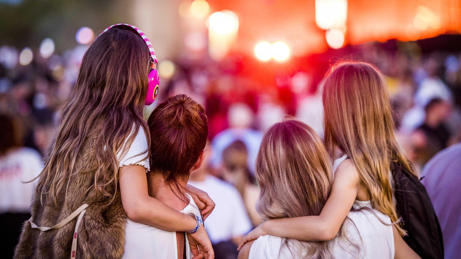 Menschen vor einer Bühne, im Vordergrund eine Familie. Menschen vor einer Bühne, im Vordergrund eine Familie.