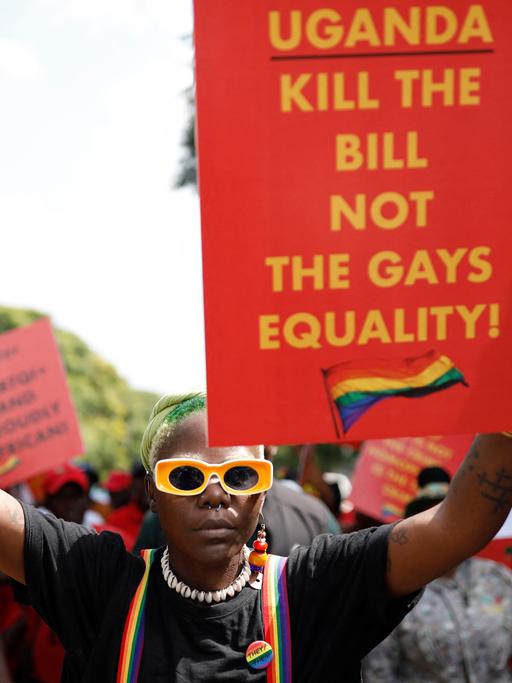 Der Queer Aktivist Papa De aus Uganda hält bei einer Demonstration im südafrikanischen Pretoria ein Plakat mit der Aufschrift: "Uganda, Kill the Bill, Not the Gays. Equality!"