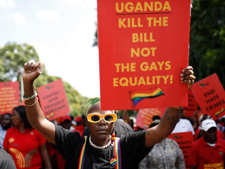 Der Queer Aktivist Papa De aus Uganda hält bei einer Demonstration im südafrikanischen Pretoria ein Plakat mit der Aufschrift: "Uganda, Kill the Bill, Not the Gays. Equality!"