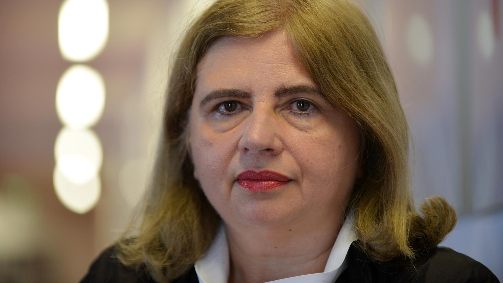 Eine etwas ältere Frau mit braunen Haaren blickt in die Kamera Eine etwas ältere Frau mit braunen Haaren blickt in die Kamera
