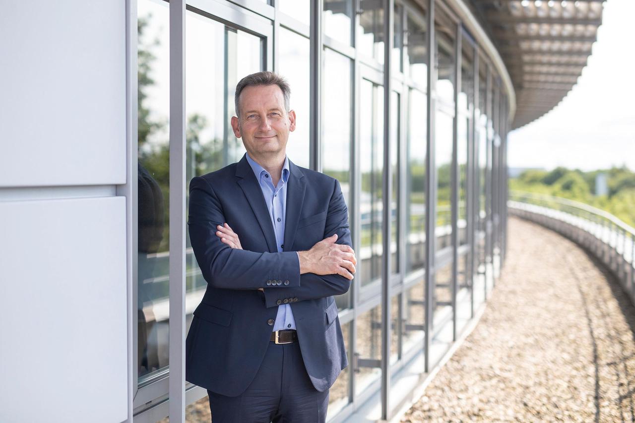 Arndt Bake steht vor dem Firmengebäude und schaut in die Kamera