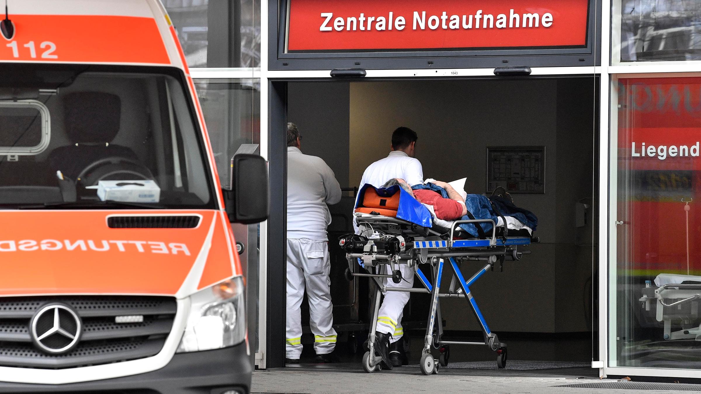 Ein Patient wird in die Zentrale Notaufnahme der Uniklinik Düsseldorf gebracht. Links im Bild steht ein Rettungswagen.