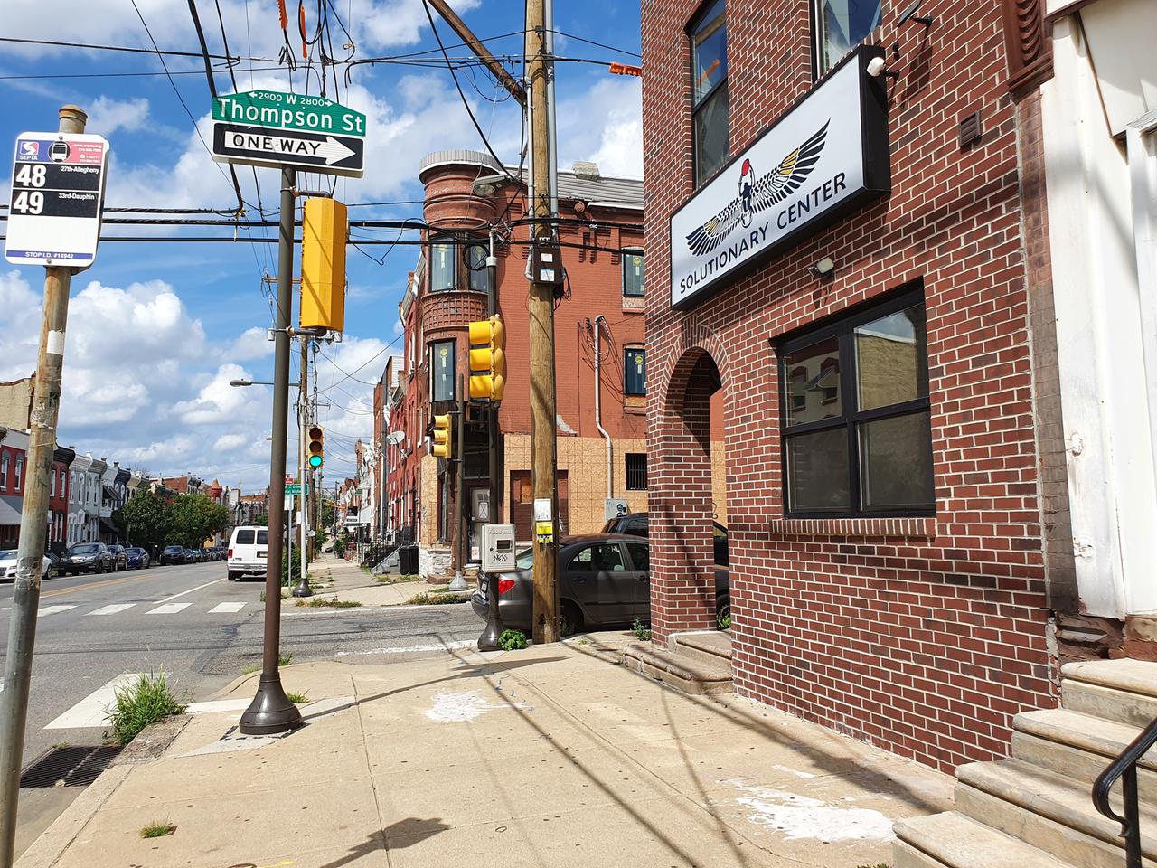 An einer Straßenecke eines Wohnviertels in Philadelphia befindet sich das Solutionary Center: rote Klinkersteine und ein großes, weißes Schild über dem Eingang.