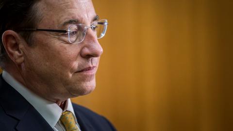 Achim Steiner ist im Profil zu sehen. Er trägt eine randlose Brille und einen dunklen Anzug und schaut nachdenklich.