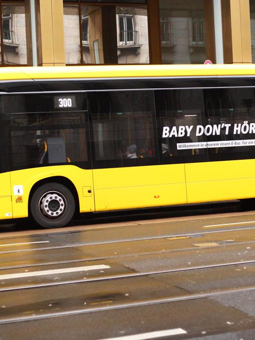 Auf einem gelben Bus in Berlin steht "Baby don't hört me" als Werbung für das leisere Elektro-Fahrzeug.