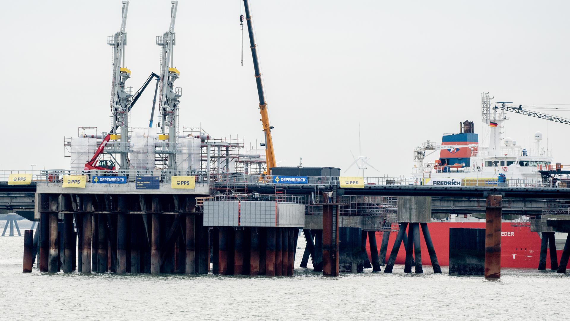 Technische Anlagen und ein Kran stehen auf dem Anleger für das LNG-Terminal in der Nordsee vor Wilhelmshaven. Der erste Anleger für Flüssigerdgas (LNG) in Deutschland ist fertiggestellt und am Dienstag eröffnet worden. In rund einem Monat soll ein beladenes Spezialschiff, eine sogenannte schwimmende Speicher- und Regasifizierungsanlage (FSRU), an dem Landungsplatz anlegen. Technische Anlagen und ein Kran stehen auf dem Anleger für das LNG-Terminal in der Nordsee vor Wilhelmshaven. Der erste Anleger für Flüssigerdgas (LNG) in Deutschland ist fertiggestellt und am Dienstag eröffnet worden. In rund einem Monat soll ein beladenes Spezialschiff, eine sogenannte schwimmende Speicher- und Regasifizierungsanlage (FSRU), an dem Landungsplatz anlegen.