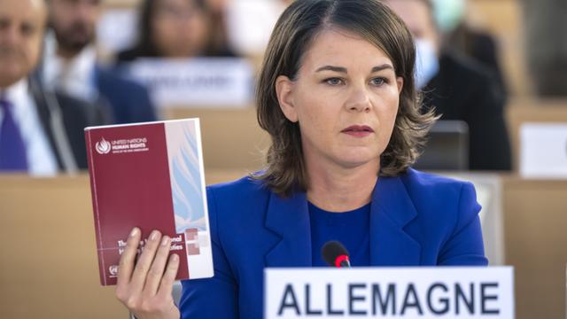 Genf: Annalena Baerbock, Außenministerin von Deutschland, spricht während einer Sondersitzung des Menschenrechtsrates. Sie hält ein Buch in die Höhe.