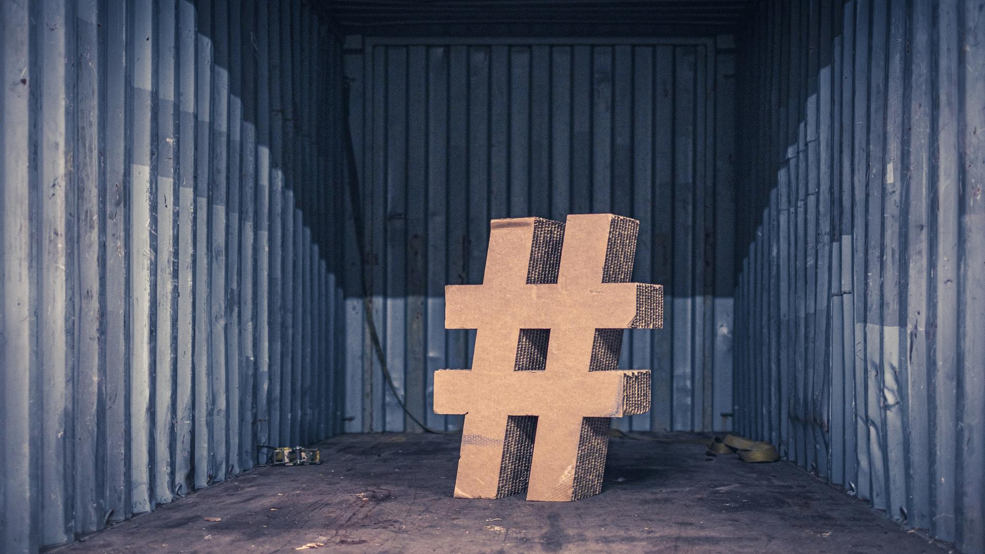 Ein Hashtag-Zeichen aus Pappkarton steht in einem Raum. Ein Hashtag-Zeichen aus Pappkarton steht in einem Raum.
