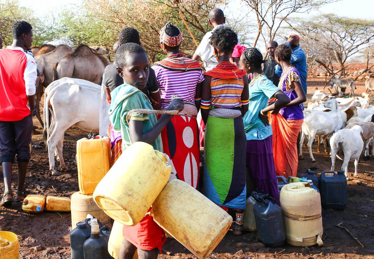 Frauen und ein Junge warten an einer Wasserstelle für Vieh in Marsabit. 