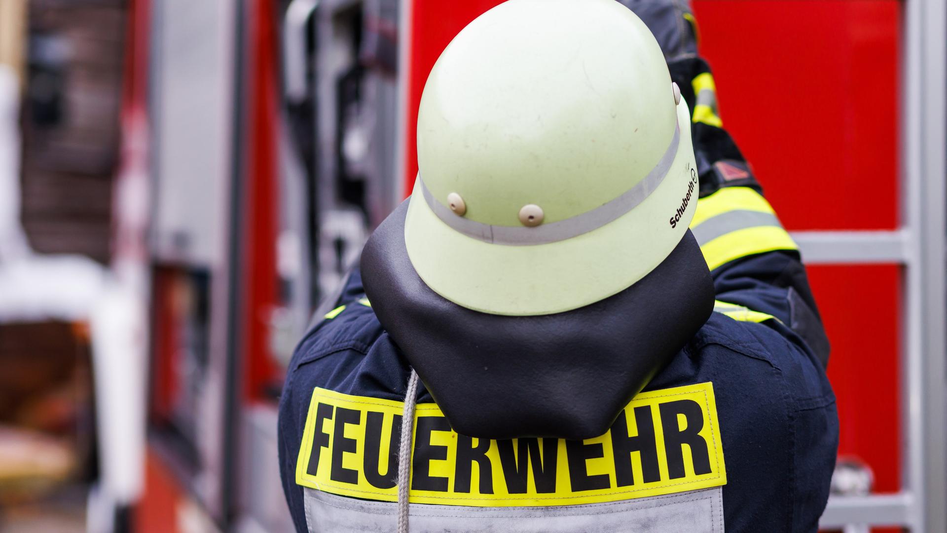 Ein Feuerwehrmann holt während einer Einsatzübung einer Freiwilligen Feuerwehr eine Leiter vom Dach eines Einsatzfahrzeugs. Ein Feuerwehrmann holt während einer Einsatzübung einer Freiwilligen Feuerwehr eine Leiter vom Dach eines Einsatzfahrzeugs.