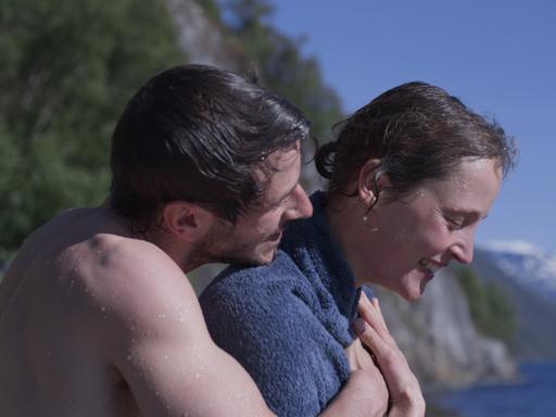 Ein Mann umarmt eine Frau von hinten am Strand. Ein Mann umarmt eine Frau von hinten am Strand.
