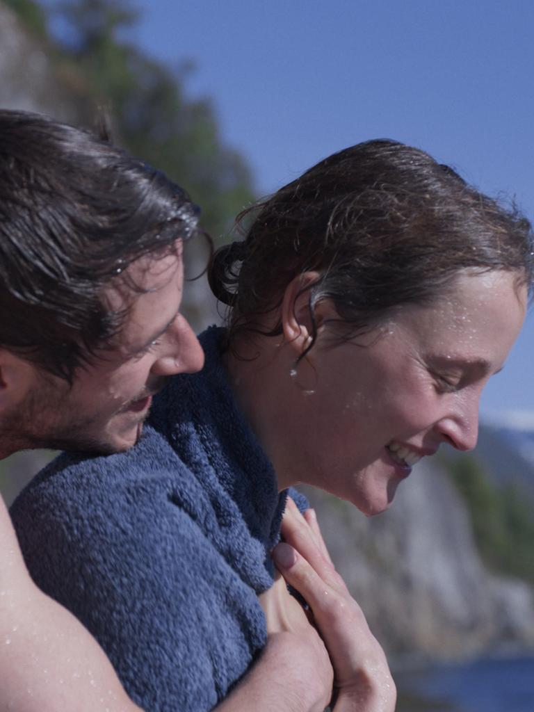 Ein Mann umarmt eine Frau von hinten am Strand. Ein Mann umarmt eine Frau von hinten am Strand.