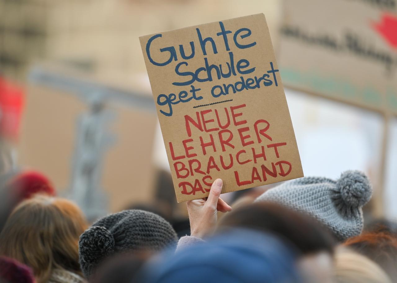 Bei einer Demonstration wird ein Schild mit der Aufschrift "Guhte Schule geet anderst. Neue Lehrer braucht das Land" hochgehalten. Bei einer Demonstration wird ein Schild mit der Aufschrift "Guhte Schule geet anderst. Neue Lehrer braucht das Land" hochgehalten.