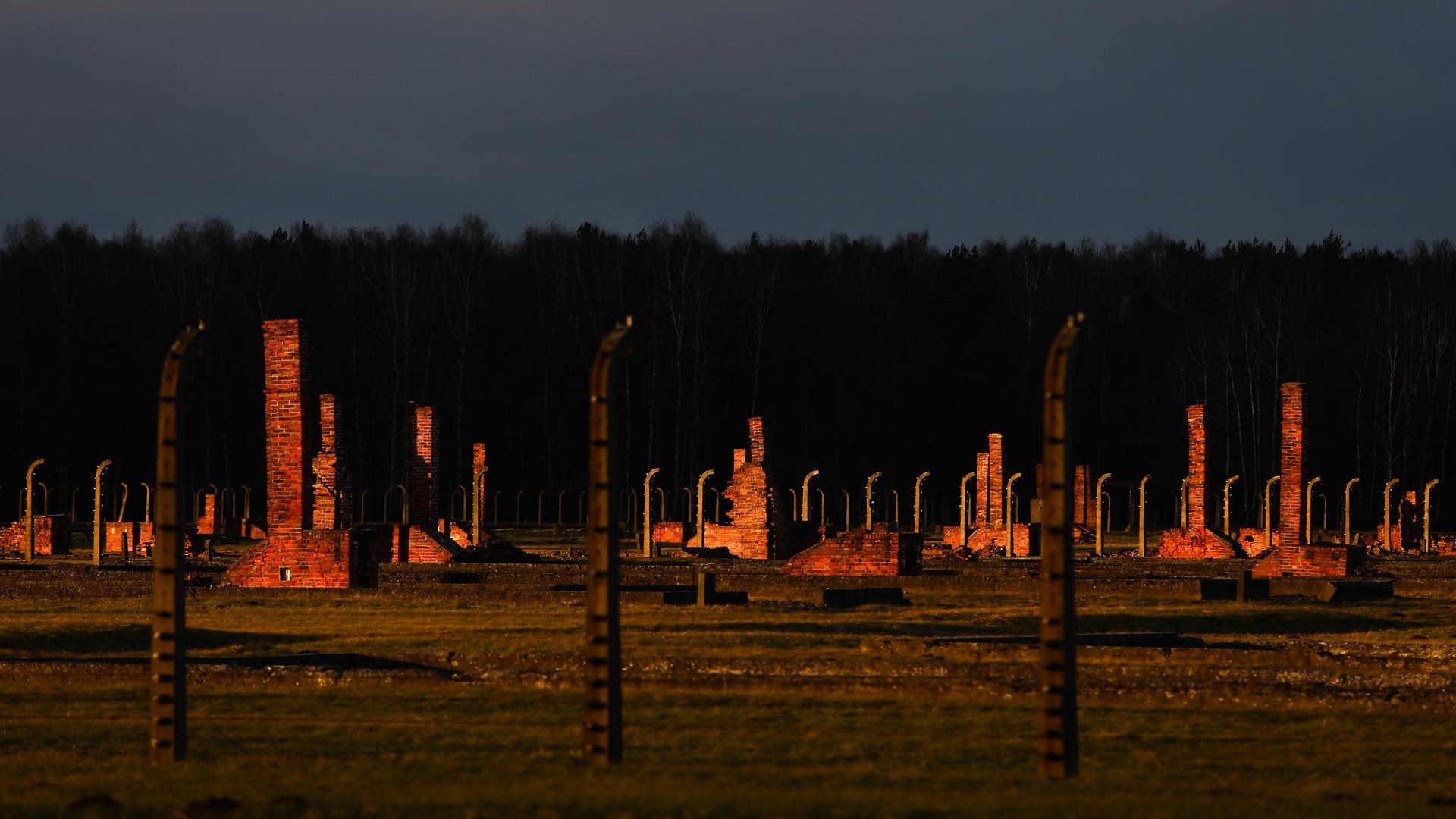 Blick auf das Lagergelände des ehemaligen deutschen nationalsozialistischen Konzentrationslages Auschwitz II-Birkenau in Brzezinka bei Oswiecim, Polen, am 3. Januar 2022. Zu sehen sind die Reste der zerstörten Baracken hinter Stacheldrahtumzeunung im Abendlicht. Blick auf das Lagergelände des ehemaligen deutschen nationalsozialistischen Konzentrationslages Auschwitz II-Birkenau in Brzezinka bei Oswiecim, Polen, am 3. Januar 2022. Zu sehen sind die Reste der zerstörten Baracken hinter Stacheldrahtumzeunung im Abendlicht.