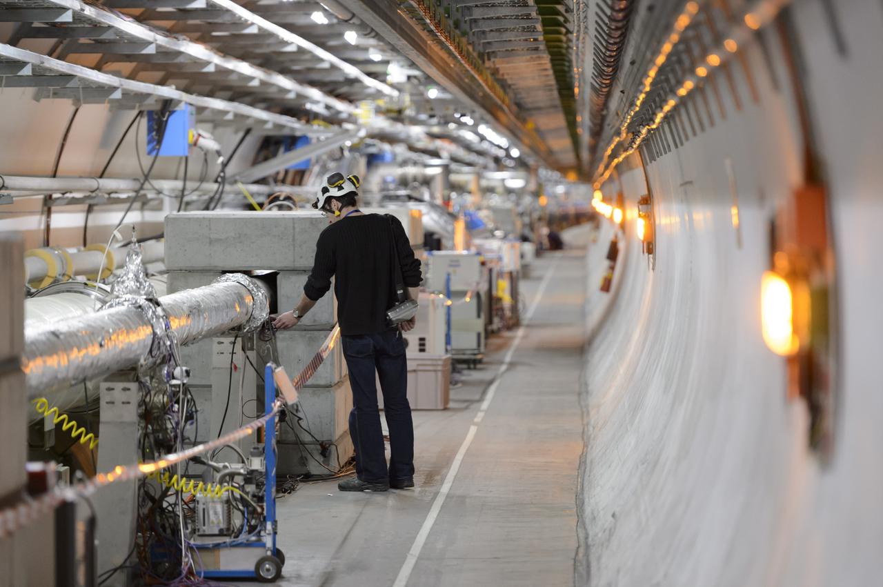 Mensch in einem Tunnel mit vielen technischen Geräten: Techniker arbeiten im LHC-Tunnel der Europäischen Organisation für Kernforschung. Mensch in einem Tunnel mit vielen technischen Geräten: Techniker arbeiten im LHC-Tunnel der Europäischen Organisation für Kernforschung.