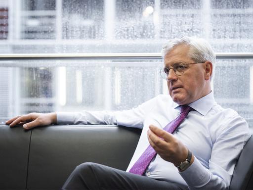 Der CDU-Außenpolitiker Norbert Röttgen sitzt während eines Interviews auf einem schwarzen Sofa. Hinter ihm ein Fenster. Er trägt ein helles Hemd und eine violette Krawatte.