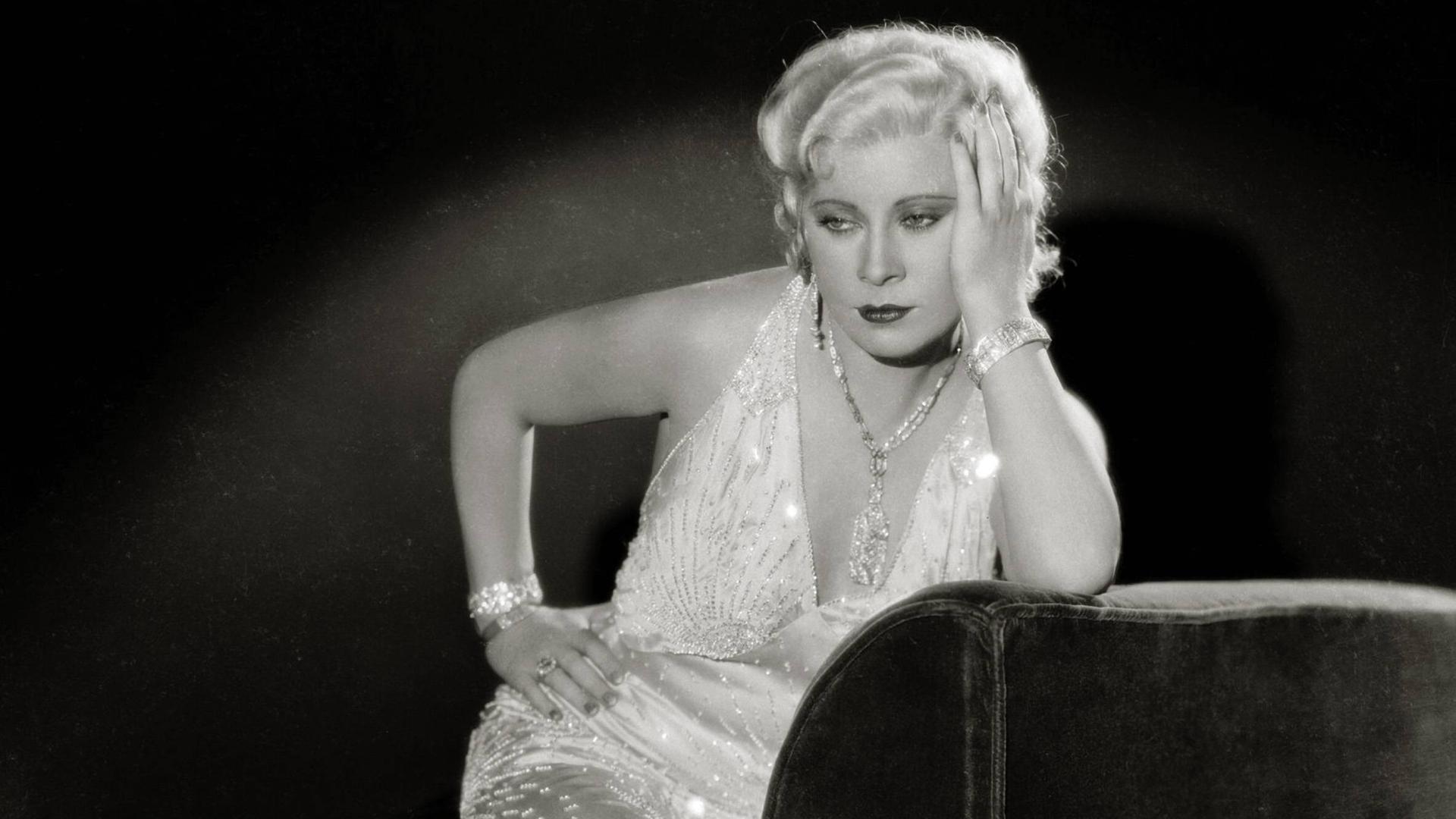 Eine historische schwarzweiss Aufnahme der Hollywood-Schauspielerin Mae West in einem glitzernden Abendkleid. Eine historische schwarzweiss Aufnahme der Hollywood-Schauspielerin Mae West in einem glitzernden Abendkleid.