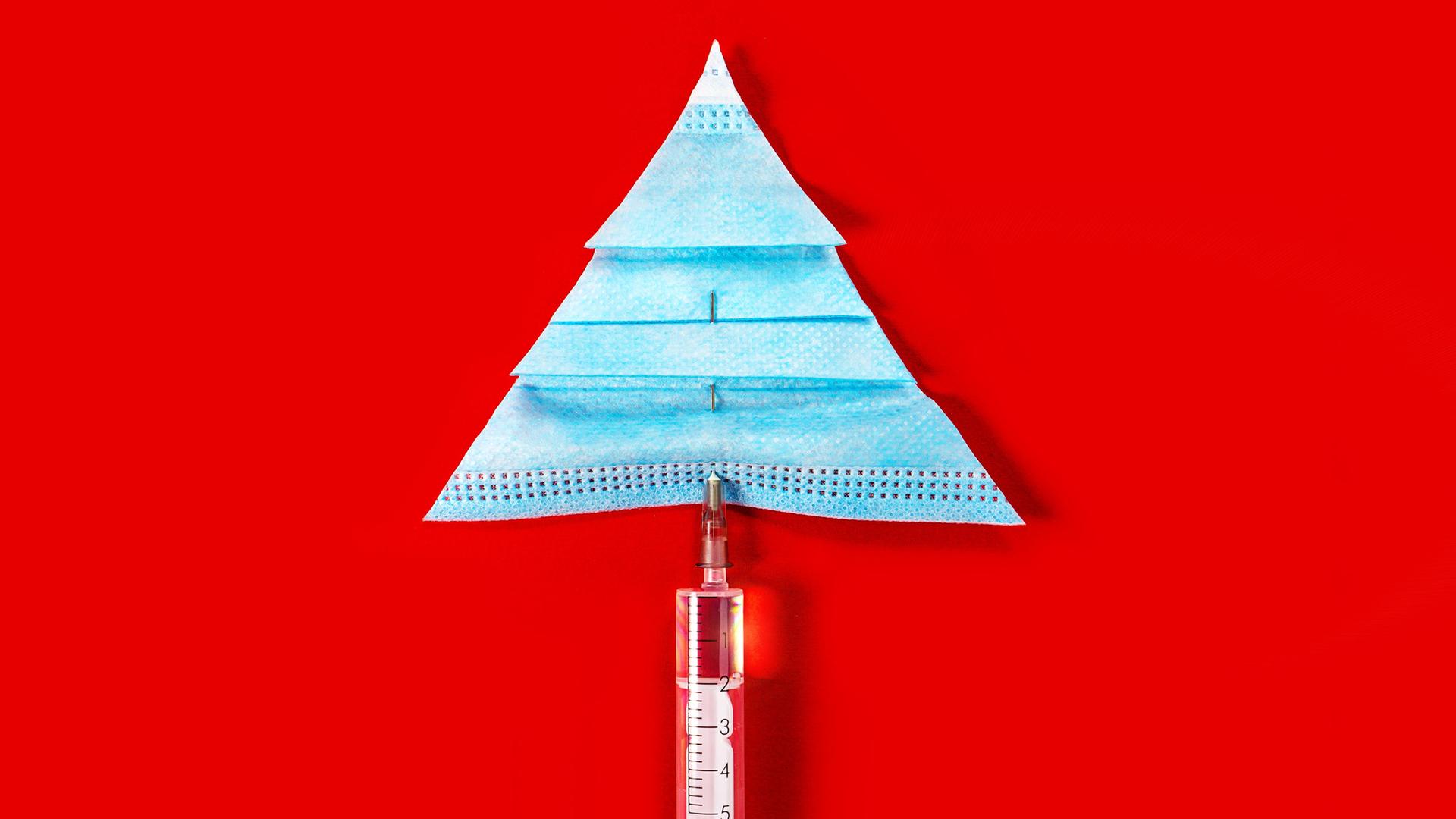 Eine Impfspritze und eine Corona-Maske, die vor rotem Hintergrund einen Tannenbaum bilden. Eine Impfspritze und eine Corona-Maske, die vor rotem Hintergrund einen Tannenbaum bilden.