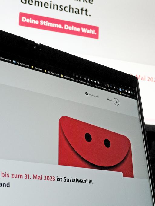 Eine Internetseite zur Sozialwahl 2023 ist auf zwei Computermonitoren zu sehen.