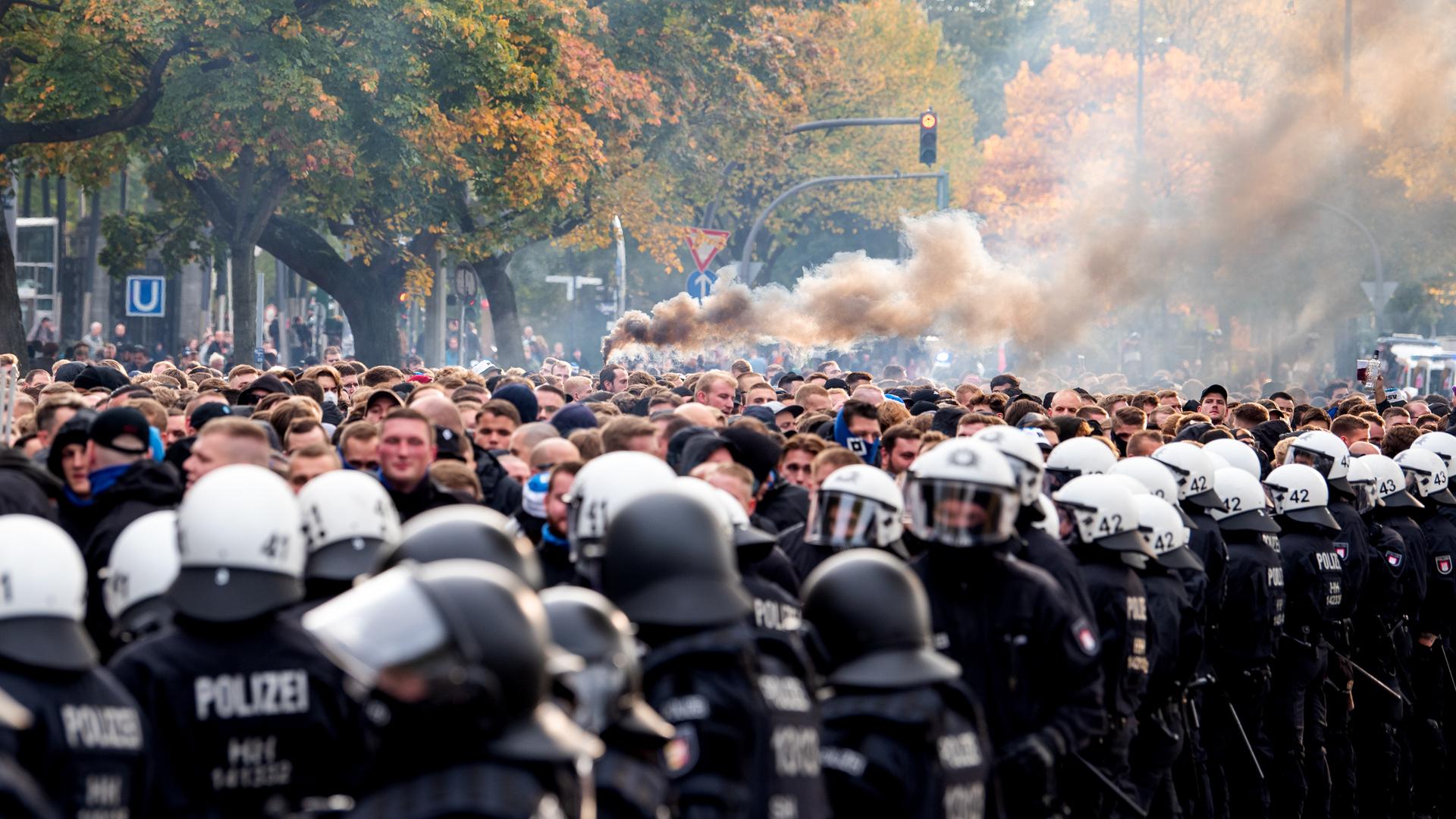 Die Fans des Hamburger SV gehen von der Polizei begleitet zum Stadion und brennen Pyrotechnik ab. Die Fans des Hamburger SV gehen von der Polizei begleitet zum Stadion und brennen Pyrotechnik ab.