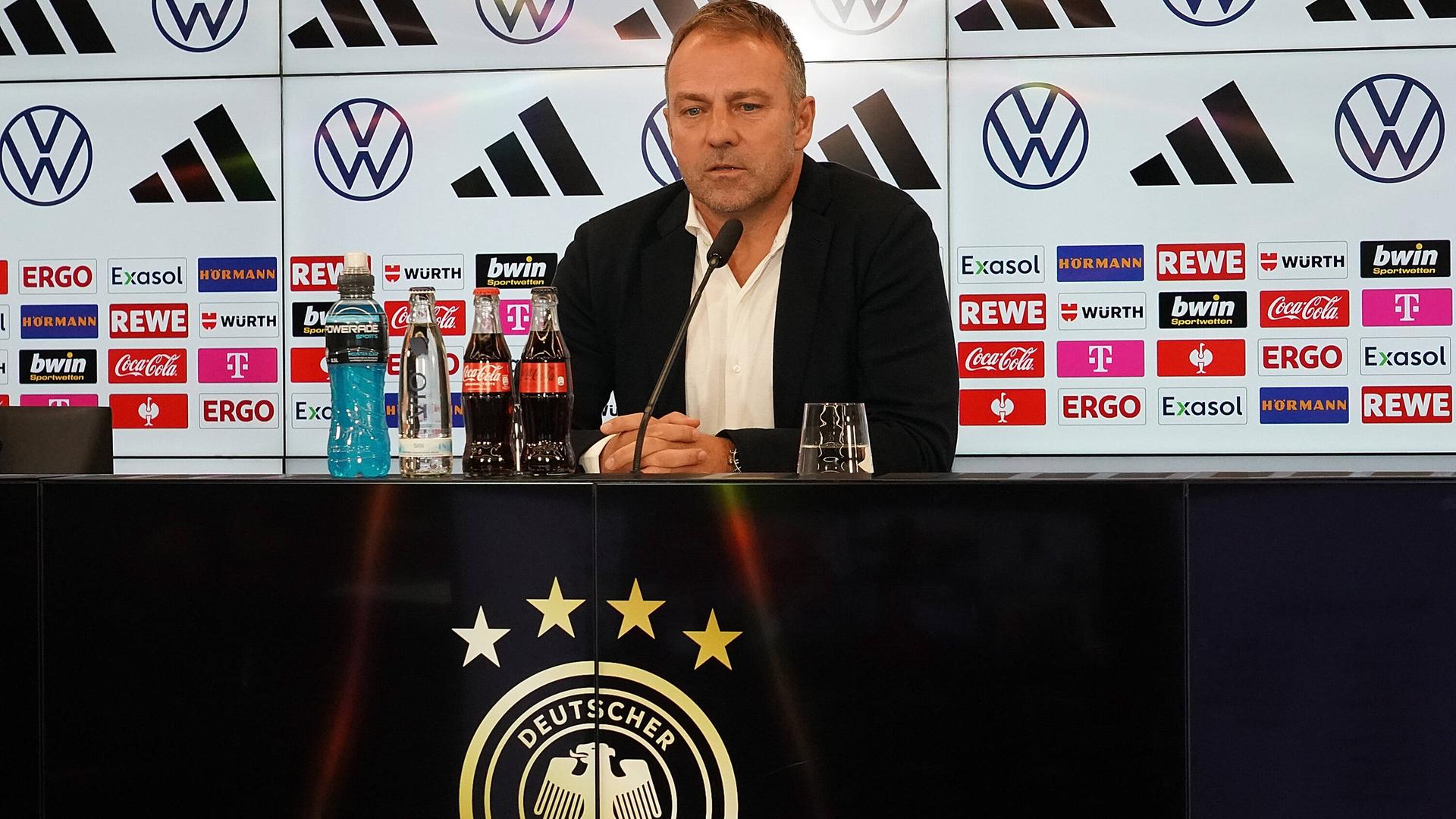 Bundes-Trainer Hansi Flick sitzt bei einer Presse-Konferenz an einem Tisch. Bundes-Trainer Hansi Flick sitzt bei einer Presse-Konferenz an einem Tisch.