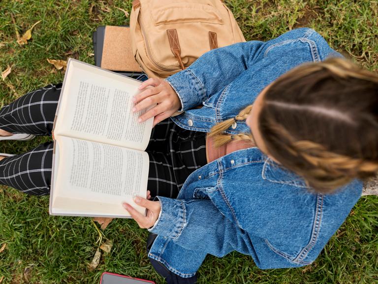 Frau im Park liest in einem Buch