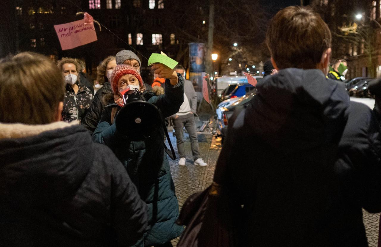 Eine Gruppe von Demonstranten mit Mundschutz, in der Mitte steht einem Frau mit einer Wollmütz, die in ein Megafon spricht. Eine Gruppe von Demonstranten mit Mundschutz, in der Mitte steht einem Frau mit einer Wollmütz, die in ein Megafon spricht.