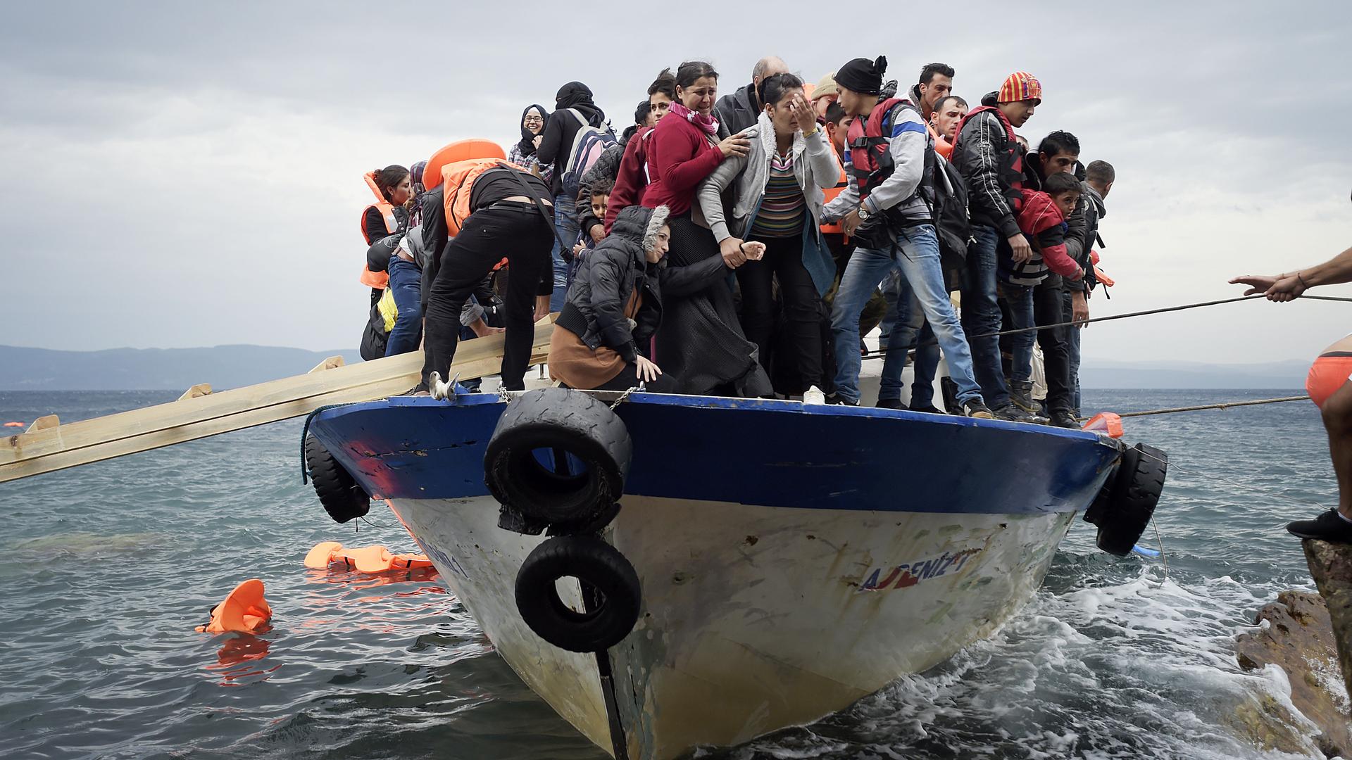 Flüchtlinge auf einem kleinen Boot erreichen die Insel Lesbos Flüchtlinge auf einem kleinen Boot erreichen die Insel Lesbos