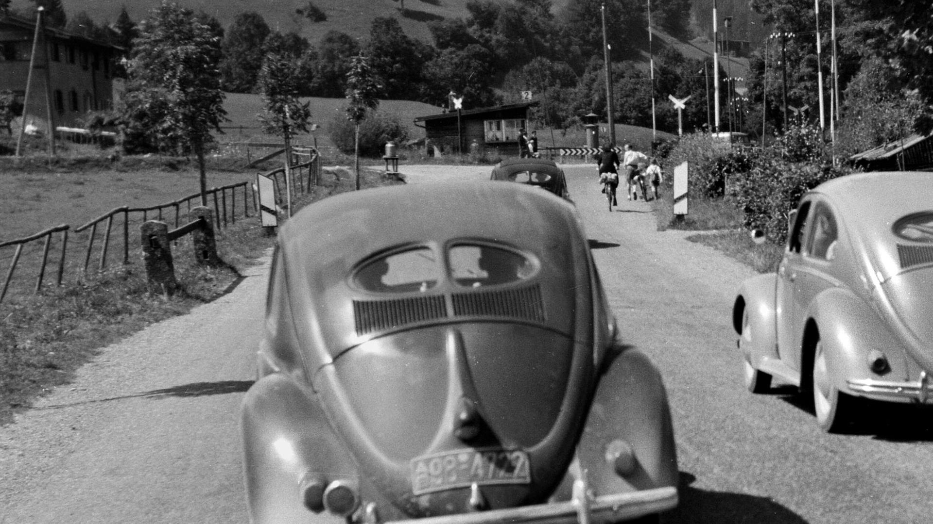 Das Hörspiel schildert Hugos Kampf mit seinem Kriegs- und Fluchtrauma in der Zeit des Wirtschaftswunders. Zu sehen: Eine Landstrasse bei München mit einem VW Käfer im Jahr 1953.