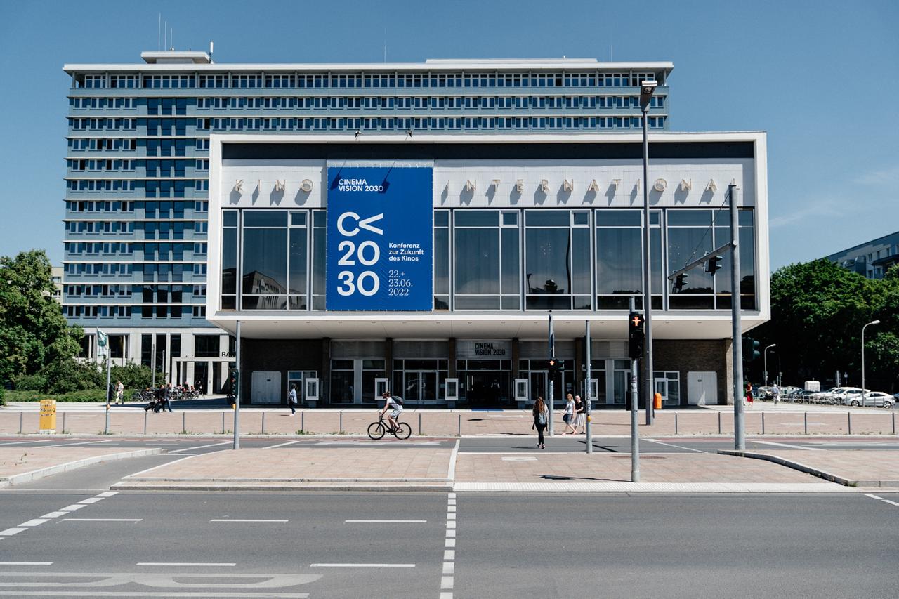 Blick auf die Fassade des Kinos International in Berlin, mit dem blauen Banner der Cinema Vision 2030 Konferenz.