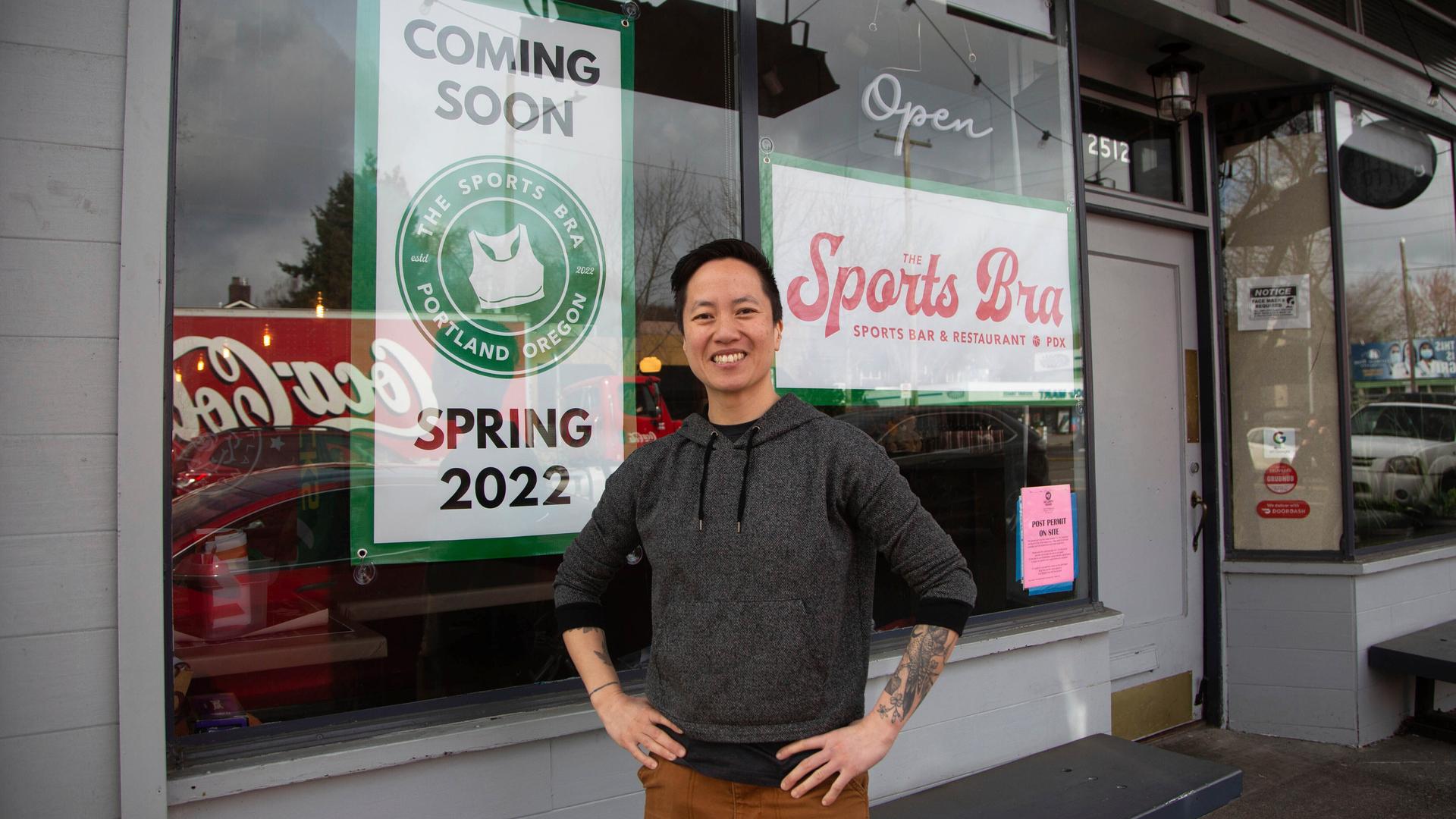 Jenny Nguyen steht lächelnd und im Hoody vor dem Schaufenster ihrer Kneipe. Jenny Nguyen steht lächelnd und im Hoody vor dem Schaufenster ihrer Kneipe.