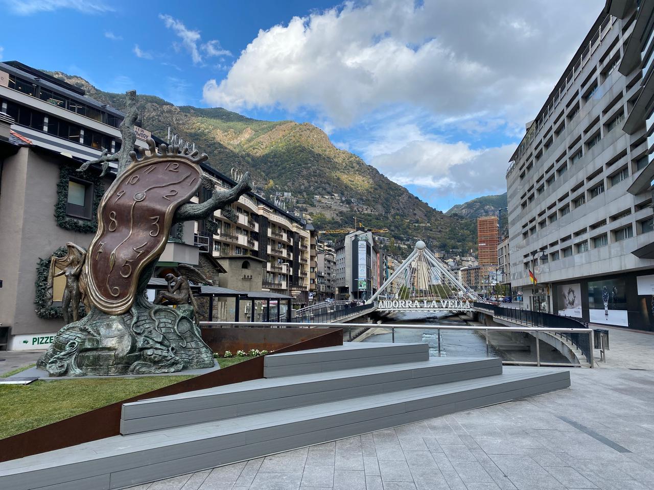 Das bekannteste Fotomotiv von Andorra - die Fußgängerzone inmitten der Berge, im Vordergrund eine große schiefe Uhr und über dem Fluß der Schriftzug "Andorra La Vella". Das bekannteste Fotomotiv von Andorra - die Fußgängerzone inmitten der Berge, im Vordergrund eine große schiefe Uhr und über dem Fluß der Schriftzug "Andorra La Vella".