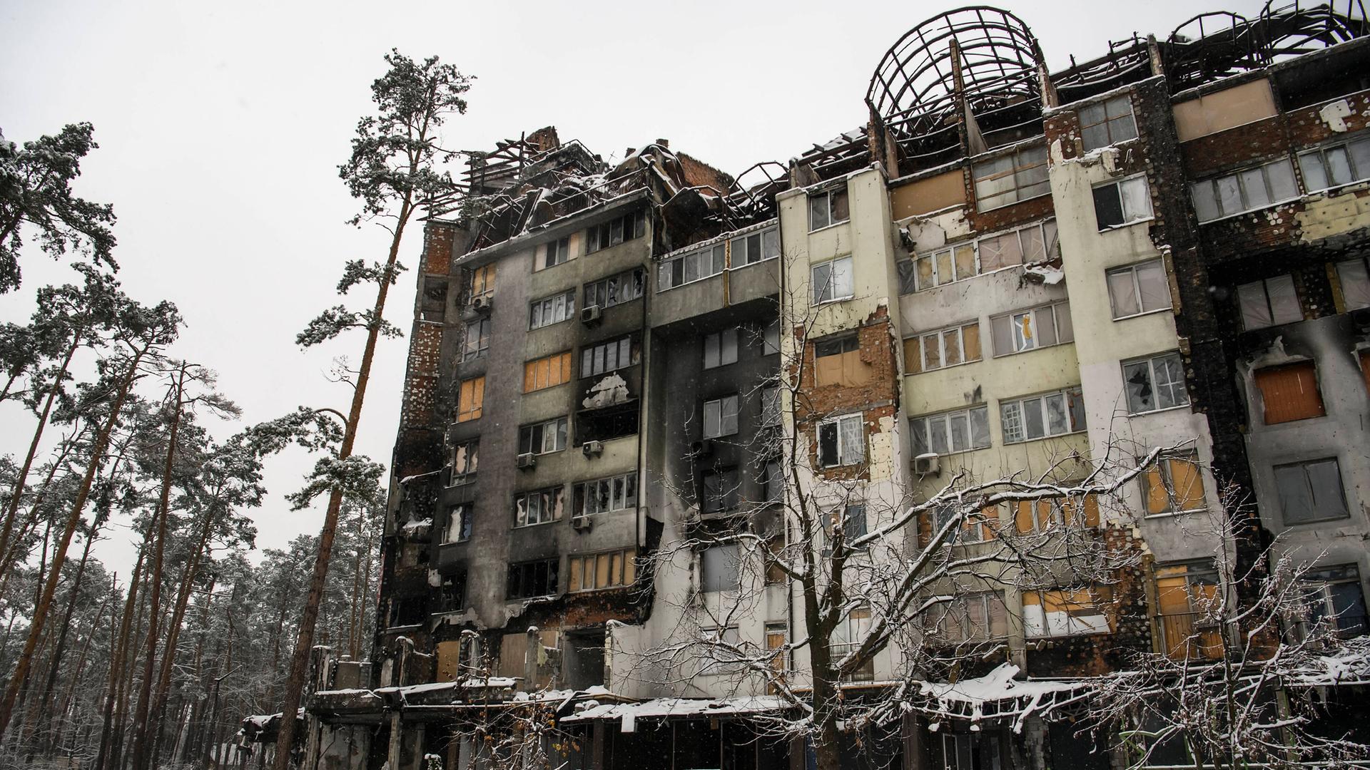 Ein Schneedecke bedeckt die Straße vor einem zerstörten Apartment-Haus in der ukrainische Stadt Irpin Ein Schneedecke bedeckt die Straße vor einem zerstörten Apartment-Haus in der ukrainische Stadt Irpin