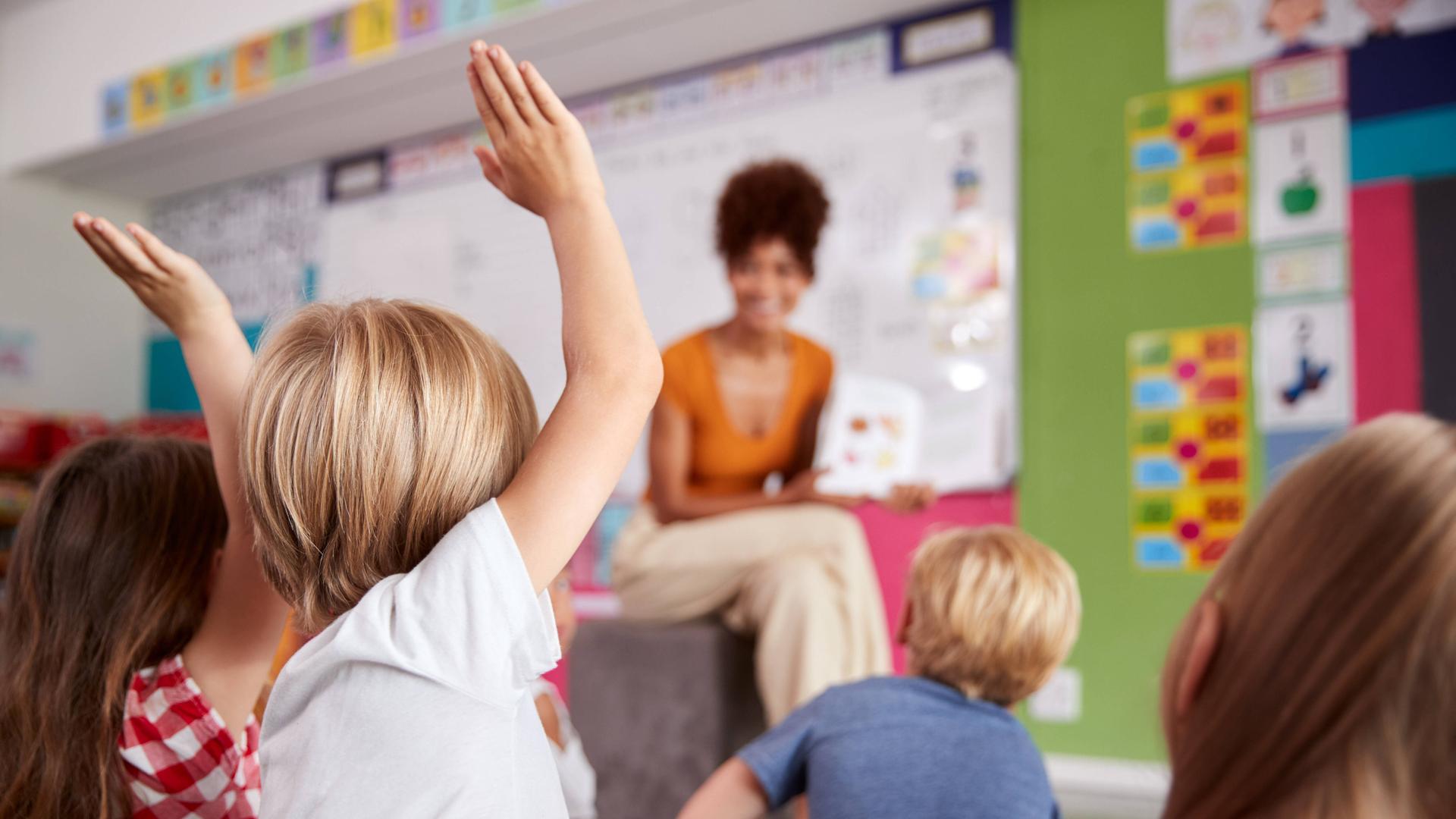 Eine Erzieherin sitz vor einer Kindergruppe in der Vorschule. Eine Erzieherin sitz vor einer Kindergruppe in der Vorschule.
