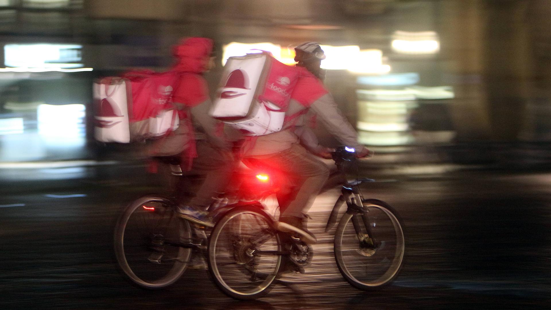 Zwei Fahrradkuriere fahren nebeneinander durch Bonn. Zwei Fahrradkuriere fahren nebeneinander durch Bonn.
