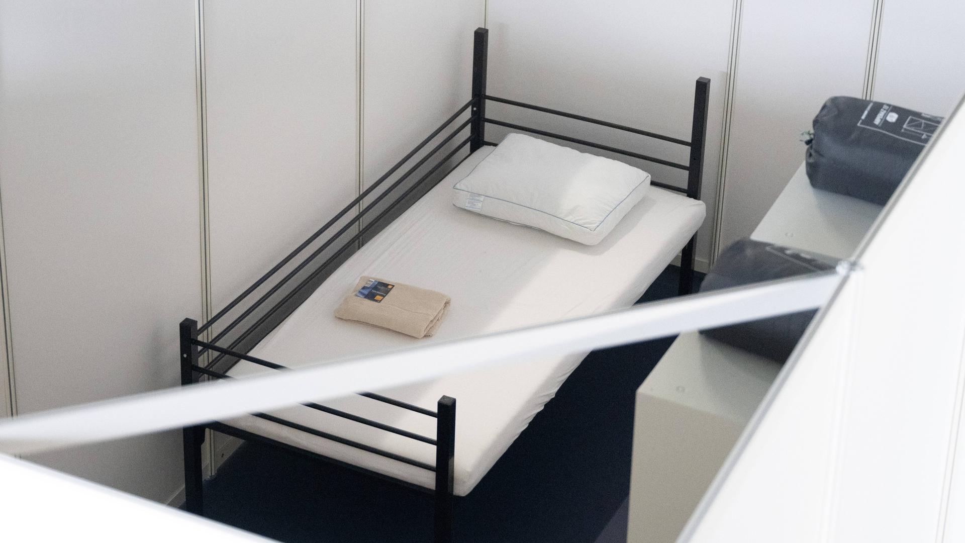 Ein Bett steht in einer Halle, die Flüchtlingsunterkunft werden sollte. Ein Bett steht in einer Halle, die Flüchtlingsunterkunft werden sollte.